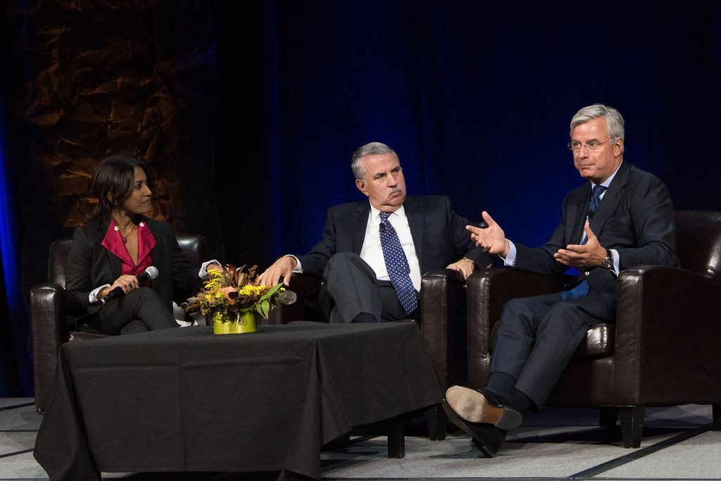 three people sitting on chairs on stage