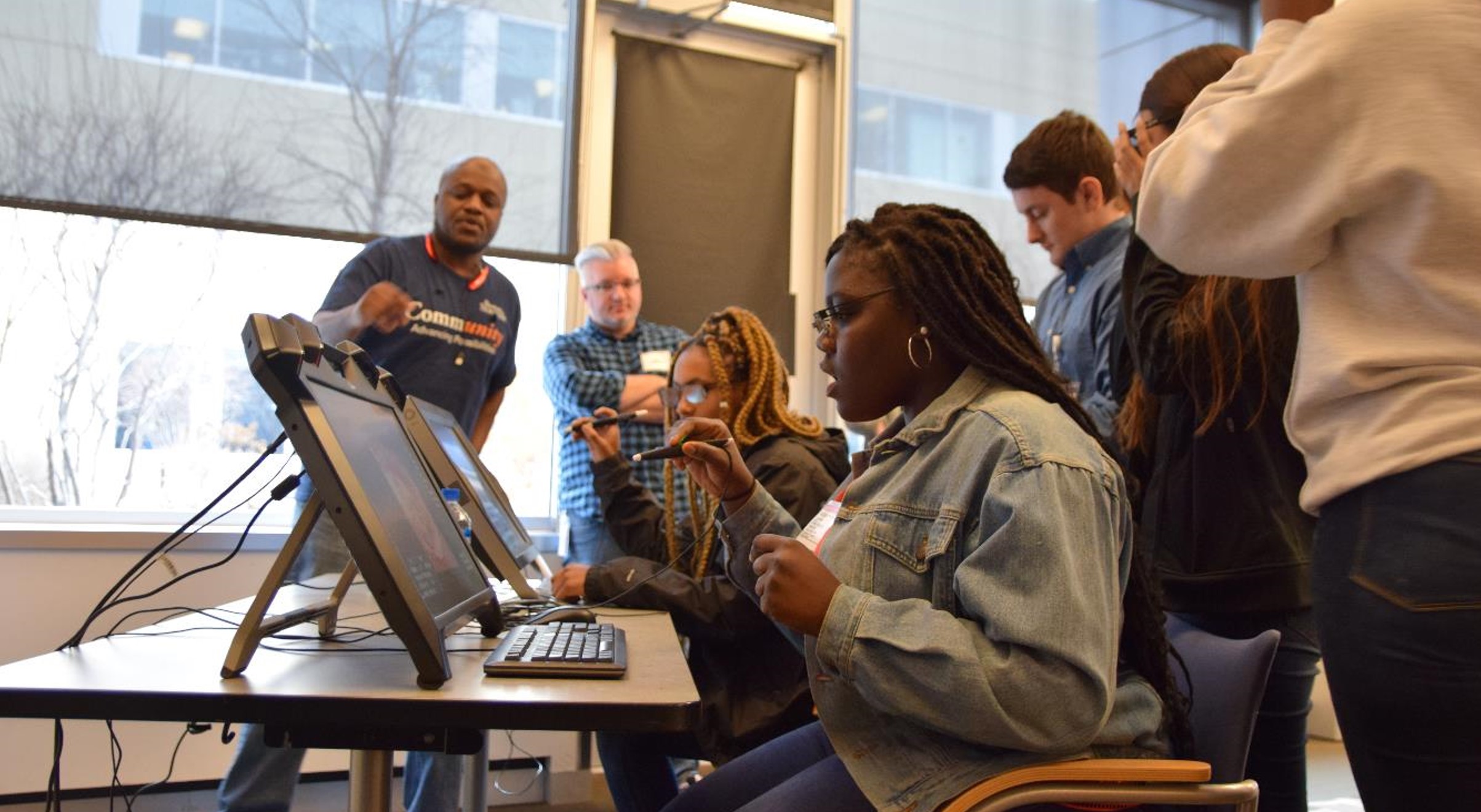 student at computer, others around her