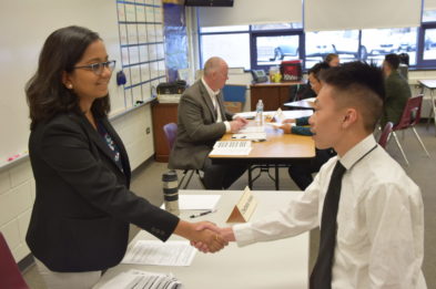adult and student shaking hands