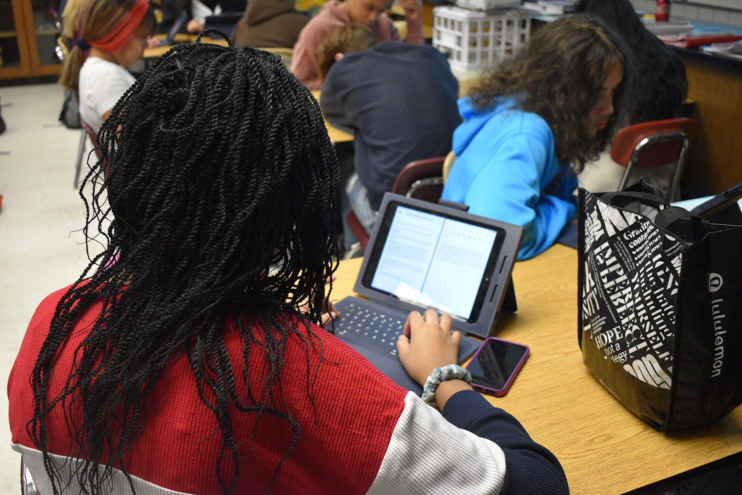 student typing on ipad