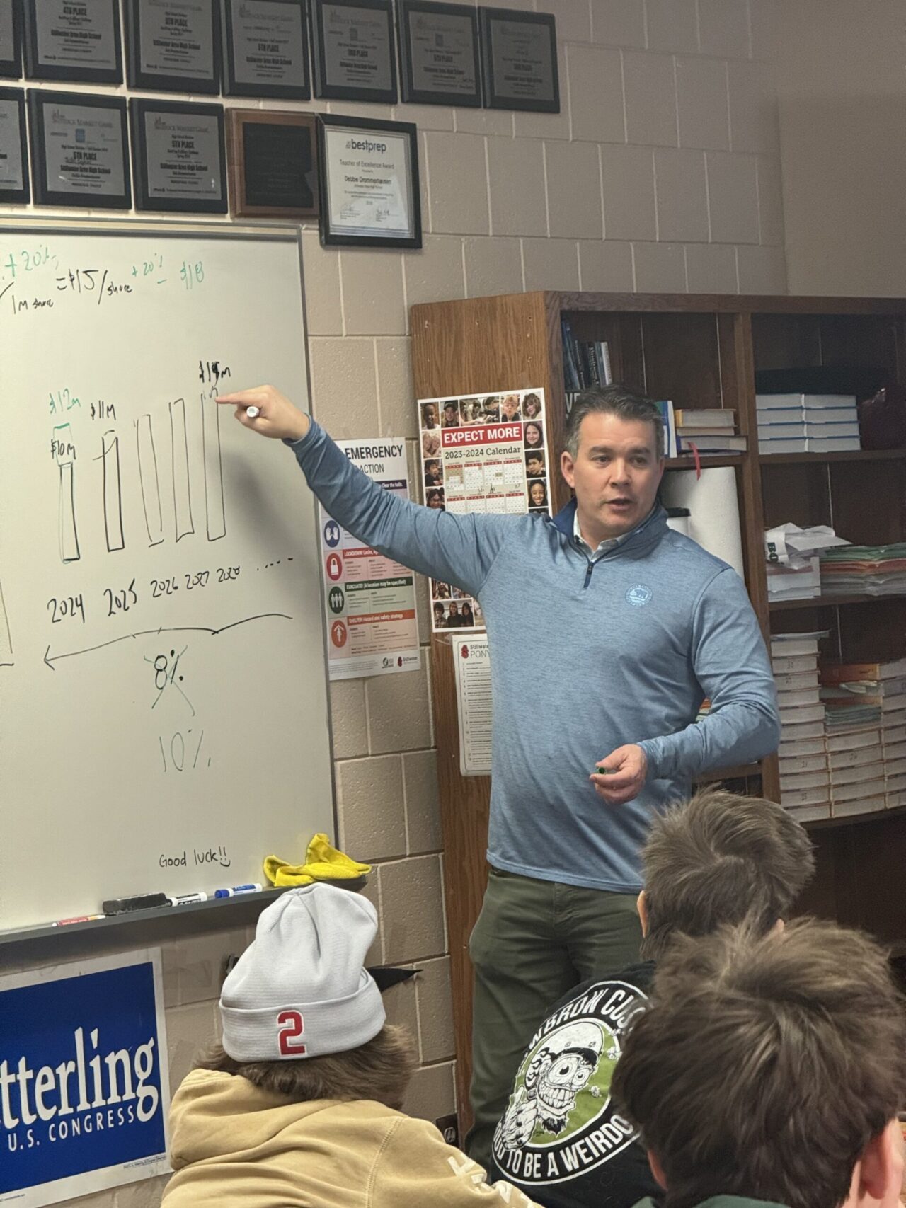 Man in front of classroom pointing to images on white board