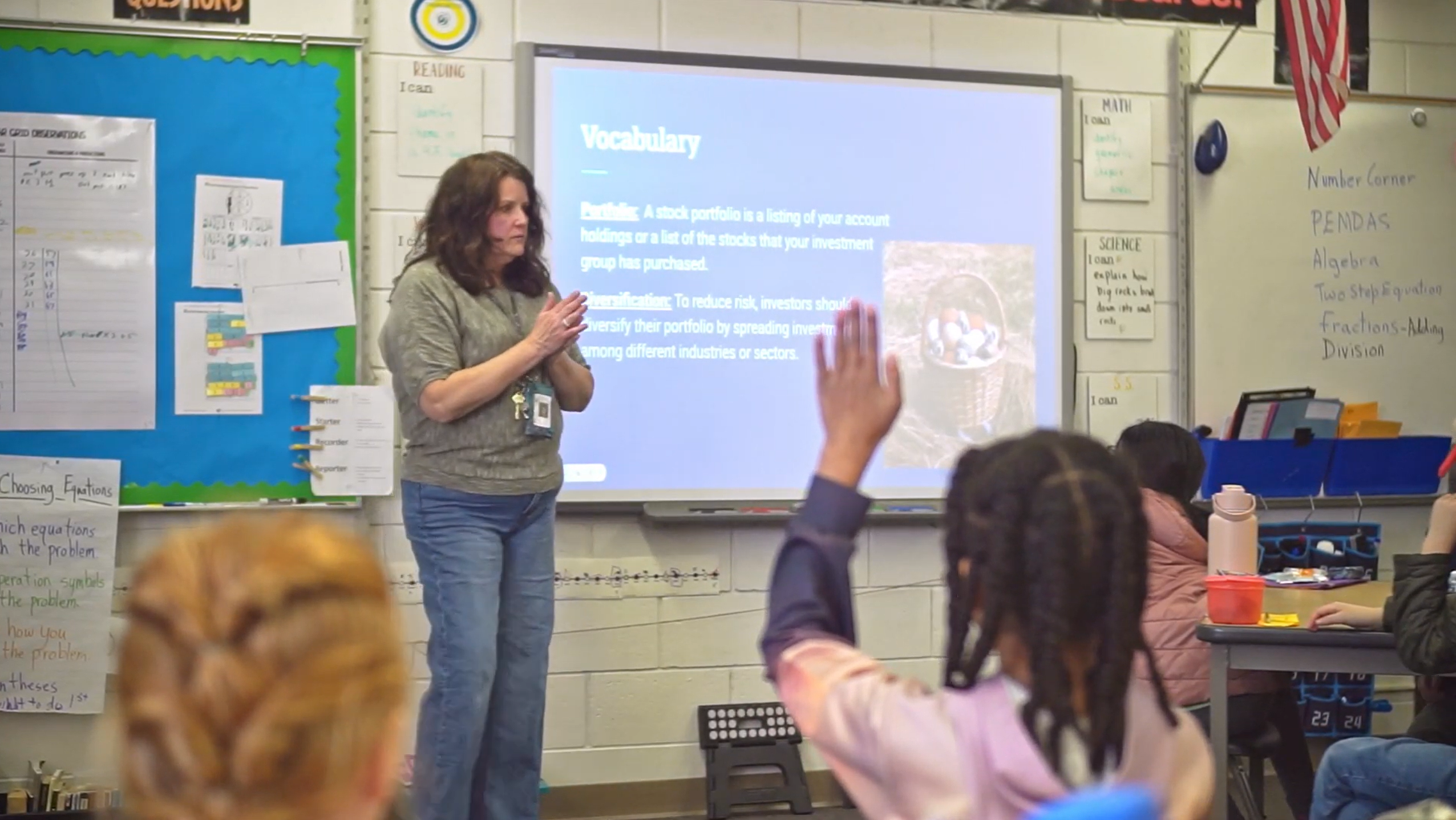 A teacher standing in front of a classroom giving a lesson.